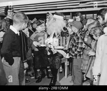 Daly City, Kalifornien: ca. 1955 der Weihnachtsmann Wird Von Einer Schar Schüler umzingelt. Stockfoto