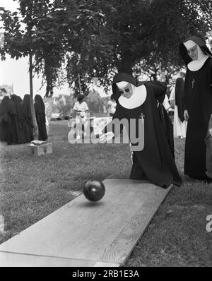 Chicago, Illinois: 1960 Nonnen Bowling am FunDay im Welles Park in Chicago. Stockfoto