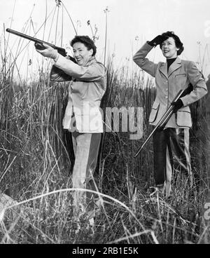 San Francisco, Kalifornien: 1953 zwei Frauen auf der Jagd auf einem Feld. Einer zielt, wie der andere zusieht. Stockfoto