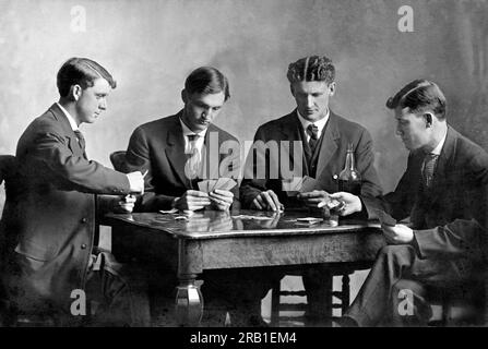 Vereinigte Staaten c; 1900. Vier junge Männer trinken und spielen Karten für Geld. Stockfoto