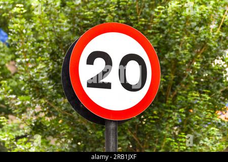 Straßenschild, das den Beginn einer Zone mit einer Geschwindigkeitsbegrenzung von 20 mph in einem Wohngebiet markiert. Keine Menschen. Stockfoto