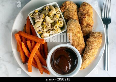 Zarte Hühnchen und Pommes Frites aus Süßkartoffeln mit Thunfisch-Makkaroni-Salat Stockfoto