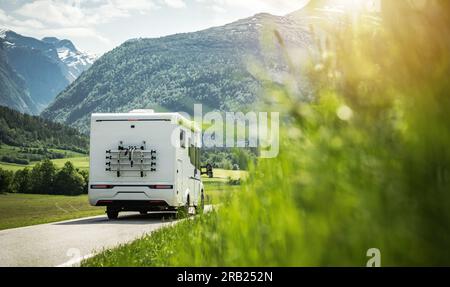 Rückansicht des weißen Wohnwagens in Richtung der wunderschönen Sommerberge. Motto „Motorheim Reisen“. Stockfoto