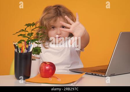 Hör auf, mich zu schikanieren Traurige und wütende Schülerin. Nerd-Schüler aus der Grundschule mit Buch isoliert auf gelbem Studiohintergrund. Intelligente, geniale Intelligenz Stockfoto