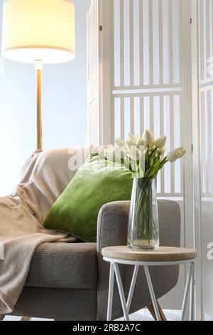 Vase mit Tulpen auf dem Tisch im Wohnzimmer Stockfoto