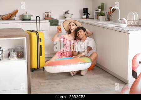 Ein junges Paar mit Bier, bereit für den Sommerurlaub in der Küche Stockfoto