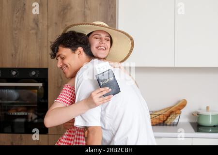 Ein junges Paar mit Reisepass, bereit für den Sommerurlaub in der Küche Stockfoto