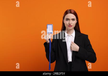 Junge Frau mit vip-Pass-Abzeichen auf orangefarbenem Hintergrund. Platz für Text Stockfoto