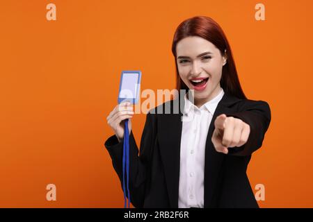 Glückliche Frau mit vip-Pass-Abzeichen auf orangefarbenem Hintergrund, Platz für Text Stockfoto