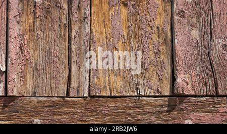 Siehe Bretter im alten Gebäude. Verwittert, lackiert, unlackiert, abblätternd kann man alles aus nächster Nähe an veralteten Holzhütten sehen. Zusammengesetzte Holzstücke. Stockfoto