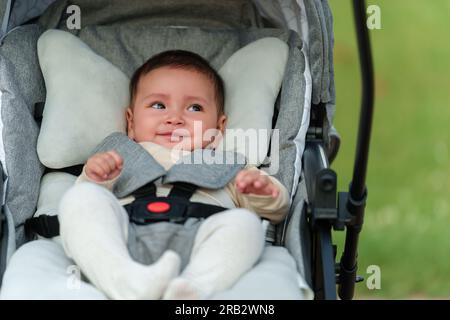 Glückliches Baby, das im Kinderwagen sitzt Stockfoto