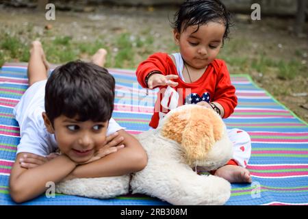 Zwei glückliche Jungs im Gesellschaftspark, glückliche asiatische Brüder, die glücklich zusammen lächeln. Brüder spielen im Sommer draußen, beste Freunde. Kleinkind Baby bo Stockfoto