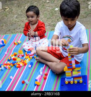 Zwei glückliche Jungs im Gesellschaftspark, glückliche asiatische Brüder, die glücklich zusammen lächeln. Brüder spielen im Sommer draußen, beste Freunde. Kleinkind Baby bo Stockfoto