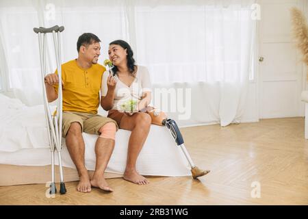 Paar Familie Beinverletzung Ehemann mit Ehefrau prothetisches bionisches Bein zusammenleben gesunde Lebensweise essen Stockfoto