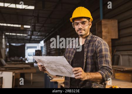 Portrait hispanic indischer Holzarbeiter glückliches Lächeln, Bauarbeiter Mann mit Grundriss Designer. Stockfoto