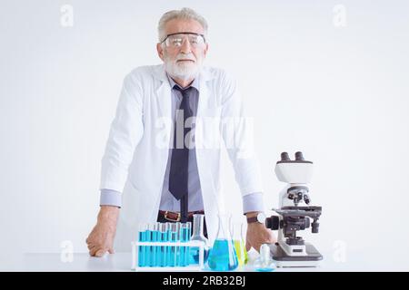 Portrait Doctor Seniorenwissenschaftler Chemiker steht auf chemischer Wissenschaftsrunde mit Mikroskop Stockfoto