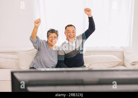 Seniorenfamilie Eldly Asiate Alter Mann und Frau genießen es, zusammen zu Hause im fernsehen Weihnachtsaktivitäten zu sehen Stockfoto