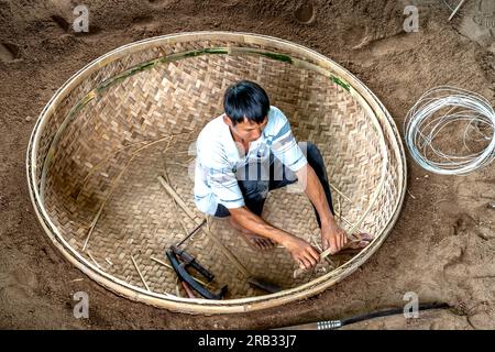 An Dan commune, Tuy an District, Phu Yen Province, Vietnam - 2. Juli 2023: Bambuskorbboot-Werkstatt für Fischer, die in der Nähe der Küste angeln Stockfoto