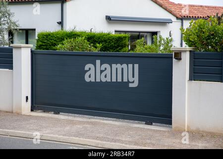 Tür graues Tor Stahl großer grauer dunkler Metall Schiebezaun elektrischer Portalzaun in moderner Hausstraße Stockfoto