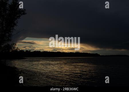 Gewitterwolken bei Sonnenuntergang über dem Dnieper River Stockfoto