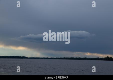 Gewitterwolken bei Sonnenuntergang über dem Dnieper River Stockfoto