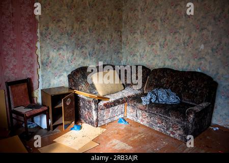 Verlassene Wohnräume in einem alten Haus vor dem Abriss, ein Chaos in einem dreckigen Zimmer Stockfoto