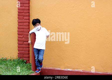 6-jähriger Latino-Junge, der eine Gesichtsmaske für die neue Normalität trägt Stockfoto