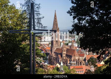 Freiburg Im Breisgau, Deutschland. 07. Juli 2023. Ein stilisiertes Kreuz steht auf dem Freiburger Schlossberg, während die Kathedrale im Hintergrund zu sehen ist. Erzbischof Georg Gänswein, der vom Papst aus dem Vatikan vertrieben wurde, ist in Freiburg eingetroffen. Das hat die deutsche Presseagentur am Freitag erfahren. Papst Franziskus hatte Mitte Juni angeordnet, dass der 66-Jährige bis Anfang Juli in die Großstadt Breisgau ziehen muss. Kredit: Philipp von Ditfurth/dpa/Alamy Live News Stockfoto