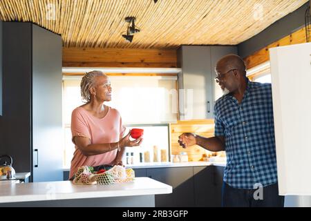 Glückliches, hochrangiges afroamerikanisches Paar, das Lebensmittel in der Küche auspackt. Senioren-Lebensstil, Entspannung, Essen, Kochen und Ruhestand, unverändert. Stockfoto