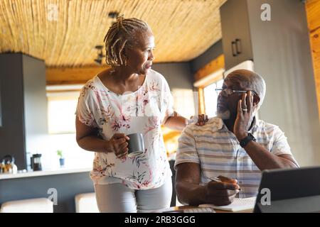 Ein hochrangiges afroamerikanisches Paar, das zu Hause Papierkram mit einem Tablet erledigt. Senioren-Lebensstil, Kommunikation, Finanzen und Ruhestand, unverändert. Stockfoto