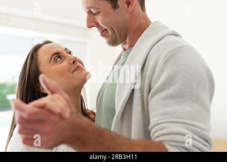 Ein glückliches weißes Paar tanzt zu Hause. Lebensstil, Freizeit, Beziehung, Zusammensein und häusliches Leben, unverändert. Stockfoto