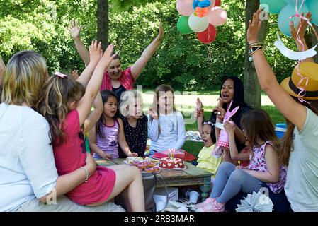 Eine Gruppe von Freunden und Familie feiert die Geburtstagsparty eines Mädchens Stockfoto