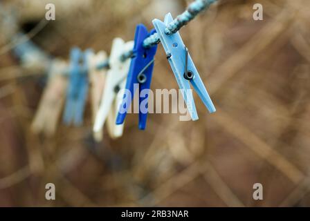 Kleider hängen im Frühling draußen im Garten an einer leeren Wäscheleine. Stockfoto