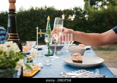 Ein Mann mit Champagnerglas zur Feier des Sommers in Schweden Stockfoto