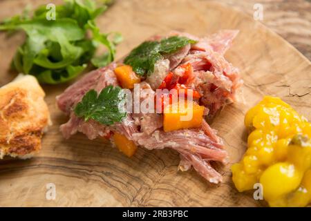 Ein hausgemachter britischer Gammonschaft, der langsam in Wasser gekocht wurde, Weißweinessig, Lorbeerblätter, Koriandersamen und schwarzer Paprika, um einen Teller zu machen Stockfoto