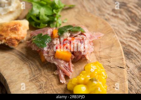 Ein hausgemachter britischer Gammonschaft, der langsam in Wasser gekocht wurde, Weißweinessig, Lorbeerblätter, Koriandersamen und schwarzer Paprika, um einen Teller zu machen Stockfoto