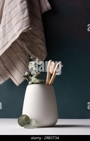 Zwei Bambuszahnbürsten in weißem Glas. Minimalistische Badezimmereinrichtung. Stockfoto