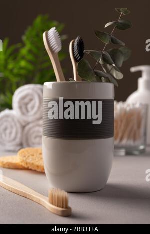 Bambuszahnbürsten in weißem Glas. Konzept der Morgenroutine im Bad. Stockfoto