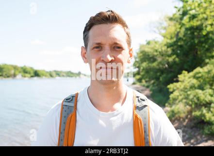 Porträt eines Mannes, der einen Rucksack beim Laufen trägt Stockfoto