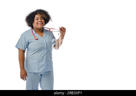 Porträt einer jungen Afro-Latina-Frau venezolanischer Herkunft, die eine blaue Uniform trägt, lächelt und in die Kamera schaut, ihr Stethoskop hält Stockfoto