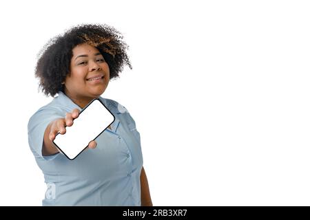 Junge Afro-lateinische Ärztin in blauer Uniform, lächelnd stehend, mit leerem Handy-Bildschirm, weißem Hintergrund mit Kopierbereich. Stockfoto