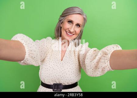 Foto Portrait der wunderschönen Oma machen Selfie Influencer Streaming tragen trendiges weißes Outfit isoliert auf grünem Hintergrund Stockfoto