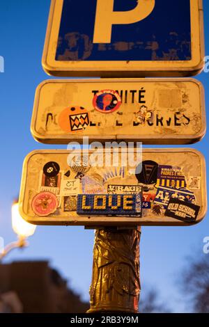 Stickerkunst, einschließlich des Wortes „LIEBE“ in Legosteinen, auf einem Parkschild in Montmartre, Paris. Stockfoto