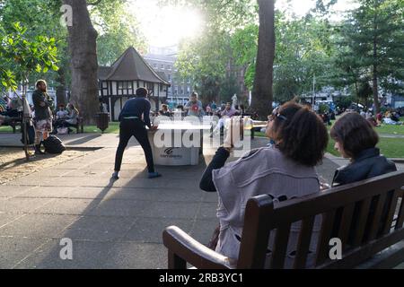 Wetter in Großbritannien, 6. Juli 2023, London: Nach ein paar kälteren Tagen kehrt das warme Wetter nach London zurück und bringt Menschenmassen nach Soho. Auf dem Soho Square genießen die Leute den sonnigen Abend, plaudern mit Freunden oder spielen Tischtennis. Kredit: Anna Watson/Alamy Live News Stockfoto