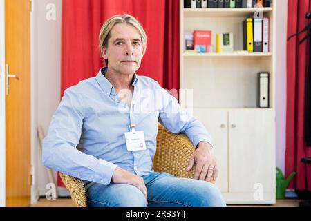 Berlin, Deutschland. 07. Juli 2023. Thomas Haustein, Suchtberater, sitzt in seinem Beratungszimmer anlässlich des 50. Jahrestags der integrativen Suchtberatung Königsberger Straße. Haustein spielte die Rolle von Detlef im Drama über einen drogenabhängigen Teenager "Christiane F. - Wir Kinder vom Bahnhof Zoo" im Alter von 15 Jahren. Mit der Gründung des Beratungszentrums Caritas im Jahr 1972 stand der Jahrestag bereits im letzten Jahr an. Wegen der Corona-Pandemie wurde die Feier auf dieses Jahr verschoben. Kredit: Christoph Soeder/dpa/Alamy Live News Stockfoto