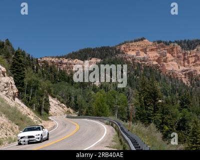 Touristen, die ein Ford Mustang Cabriolet auf dem Highway 14 Utah auf dem Weg nach Cedar fahren, brechen das Nationaldenkmal Stockfoto