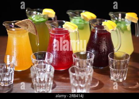 Kalte Limonaden. Beerenlimonade. Erfrischender Durst und erfrischende Getränke. Limonade in der Kanne und Zitronen mit Minze auf dem Tisch drinnen. Stockfoto