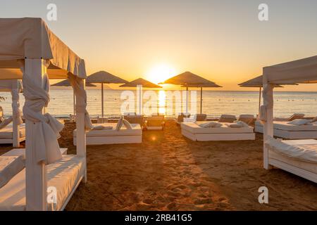 Schöner Sonnenuntergang oder Sonnenaufgang am Strand. Stockfoto