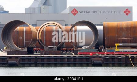 Rostock, Deutschland. 07. Juli 2023. Große Fundamente für Windturbinen des Rohrherstellers Special Pipe Construction EEW befinden sich im Hafen Rostock. Rostock Port wird seine Halbjahresergebnisse auf einer Pressekonferenz am 07.07.2023 vorstellen. In den ersten sechs Monaten dieses Jahres passierten 15,8 Millionen Tonnen Güter am Kai im Überseehafen von Rostock. Dies ist ein Anstieg von zehn Prozent im Vergleich zum Vorjahr. Die Zahl der beförderten Fährpassagiere stieg um fünf Prozent auf eine Million. Kredit: Bernd Wüstneck/dpa/Alamy Live News Stockfoto