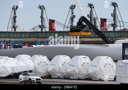 Rostock, Deutschland. 07. Juli 2023. Teile für Windturbinen werden im Überseehafen von Rostock abgewickelt, im Hintergrund steht das Kranwerk von Liebherr. Rostock Port präsentiert seine Halbjahresergebnisse auf einer Presseveranstaltung am 07.07.2023. In den ersten sechs Monaten dieses Jahres wurden 15,8 Millionen Tonnen Güter über die Kairänder im Überseehafen von Rostock transportiert. Dies ist ein Anstieg von zehn Prozent im Vergleich zum Vorjahr. Die Zahl der beförderten Fährpassagiere stieg um fünf Prozent auf eine Million. Kredit: Bernd Wüstneck/dpa/Alamy Live News Stockfoto